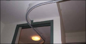 Rail de lève-personne de plafond passant dans une ouverture de porte